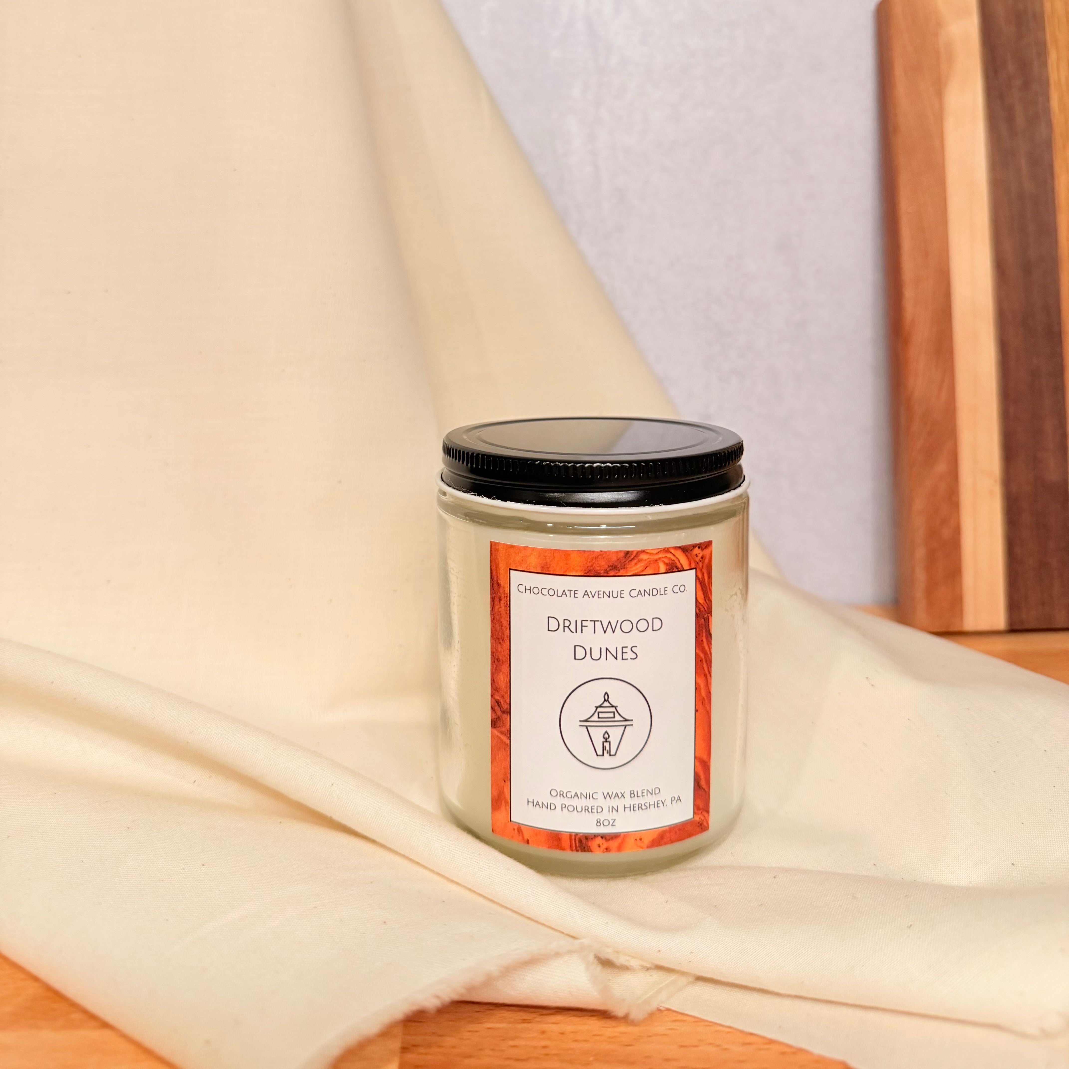 Driftwood Dunes candle with sun-warmed driftwood, pine needles, and ocean air notes.