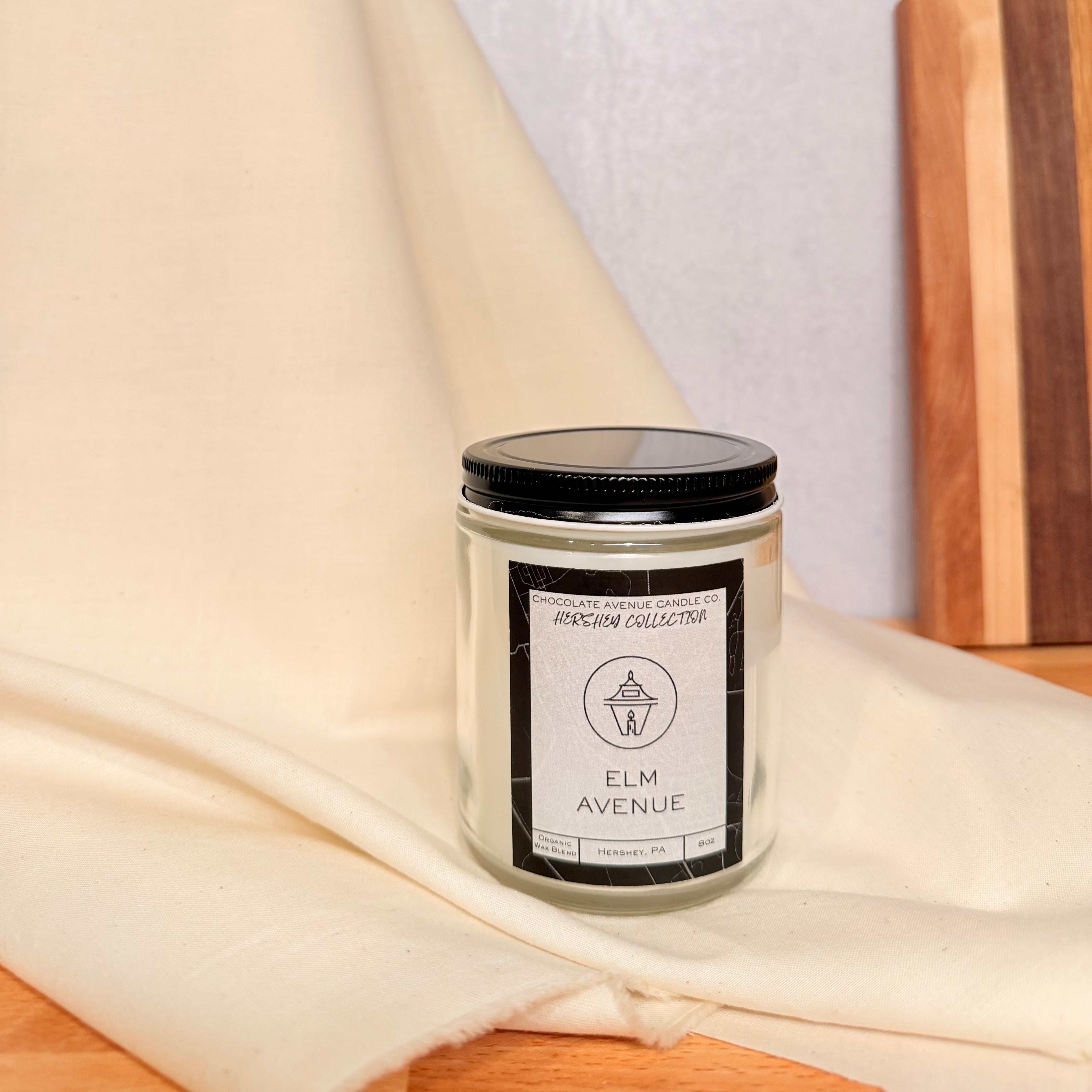 Elm Avenue candle with palo santo and warm wood fragrance notes.